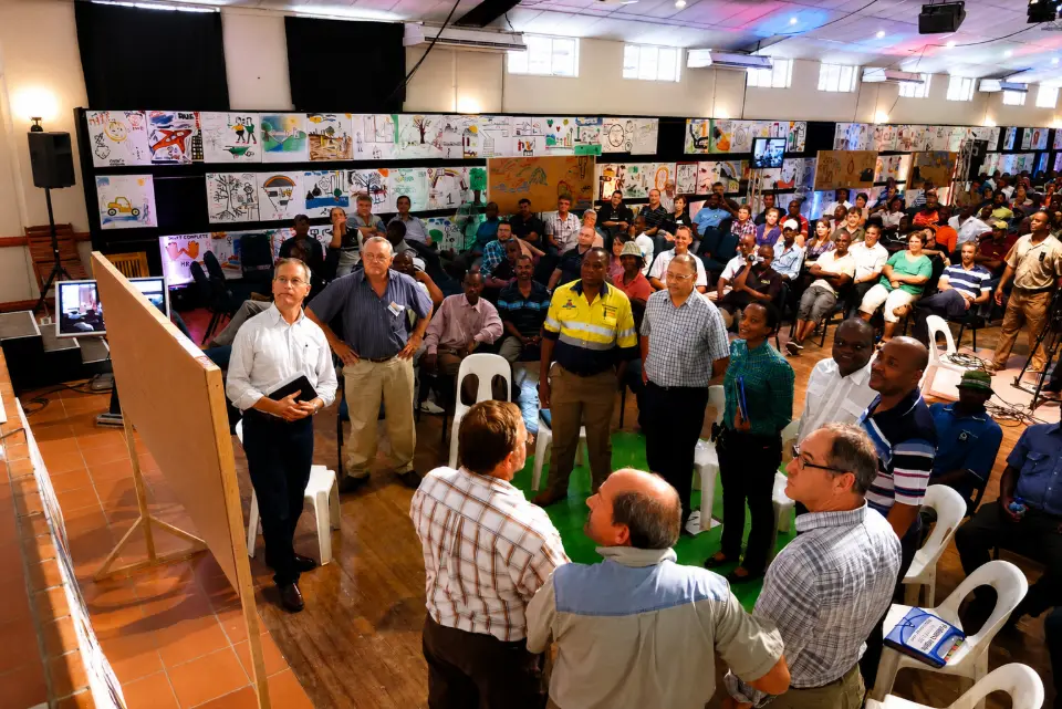 Participants gathered in a hall lined with artworks