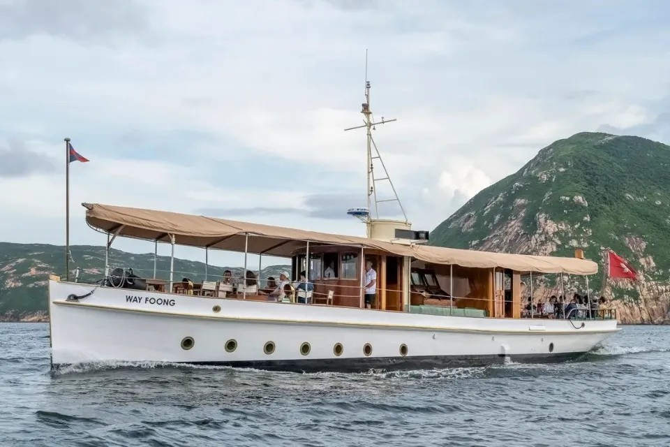 Wayfoong cruising past a green headland