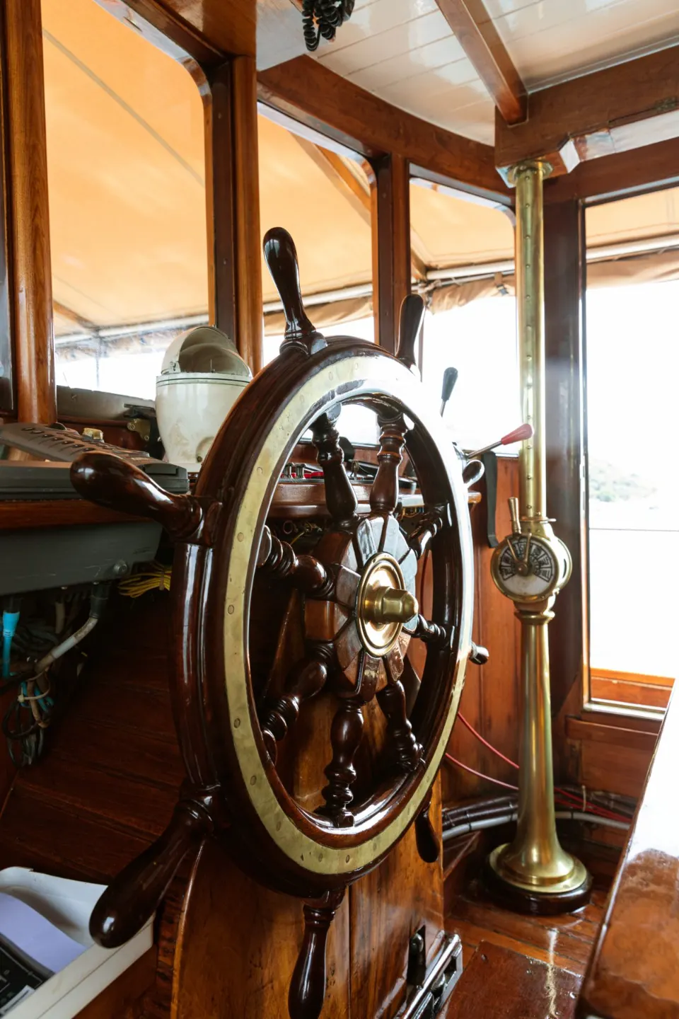Wooden ship’s wheel and brass fittings in the wheelhouse of Wayfoong